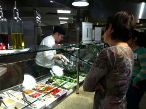 A chef tosses a customer's salad to order at Green Leaf Grill.