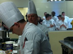 Chef Philippe Ducrot of Pulaski Tech (right) looks on as his sous works on a basket ingredient. 