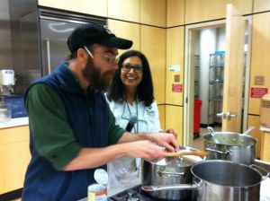 Root Café owner and chef Jack Sundell prepares the restaurant's Coconut Curry Collard Greens with Dr. Meenakshi Budrahaja. 