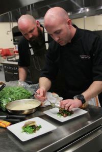 Chef Justin Patterson (right) and sous chef Daniel Rogers plating during the competition. The team won the preliminaries and will compete against Marc Guizol in the final on June 2. 